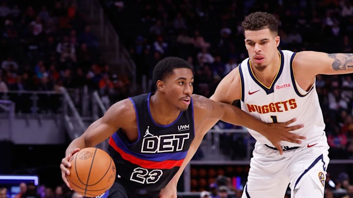 Nov 20, 2023; Detroit, Michigan, USA;  Detroit Pistons guard Jaden Ivey (23) dribbles defended by Denver Nuggets forward Michael Porter Jr. (1) in the second half at Little Caesars Arena. Mandatory Credit: Rick Osentoski-USA TODAY Sports