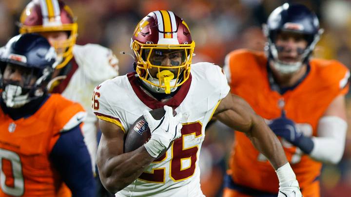 Nov 30, 2025; Landover, Maryland, USA; Washington Commanders running back Jeremy McNichols (26) carries the ball against the Denver Broncos in the first quarter of the game at Northwest Stadium. Mandatory Credit: Peter Casey-Imagn Images Nov 30, 2025; Landover, Maryland, USA; Washington Commanders running back Jeremy McNichols (26) carries the ball against the Denver Broncos in the first quarter of the game at Northwest Stadium. Mandatory Credit: Peter Casey-Imagn Images