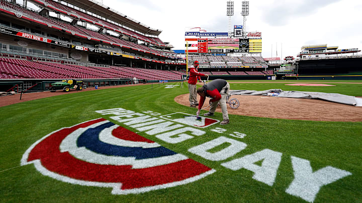 The Cincinnati Reds groundscrew paints the Opening Day logo behind home plate, Tuesday, March 28,