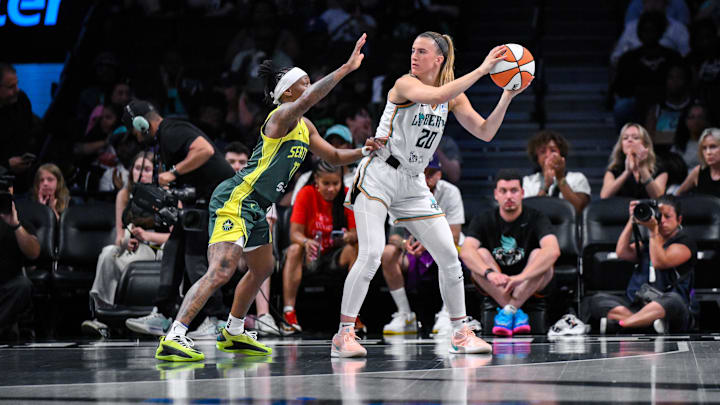 Jul 6, 2025; Brooklyn, New York, USA; New York Liberty guard Sabrina Ionescu (20) looks to pass the ball as Seattle Storm guard Erica Wheeler (17) defends during the first half at Barclays Center. Mandatory Credit: John Jones-Imagn Images