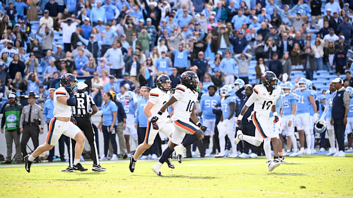 Oct 25, 2025; Chapel Hill, North Carolina, USA;  Virginia Cavaliers players celebrate after stopping North Carolina Tar Heels short of the goal line on a two point try to win in overtime at Kenan Stadium. Mandatory Credit: Bob Donnan-Imagn Images