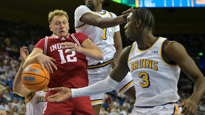 Jan 31, 2026; Los Angeles, California, USA;  Indiana Hoosiers forward Tucker DeVries (12) and UCLA Bruins forward Xavier Booker (1) and guard Eric Dailey Jr. (3) go for a rebound in the first half at Pauley Pavilion presented by Wescom Financial. Mandatory Credit: Jayne Kamin-Oncea-Imagn Images