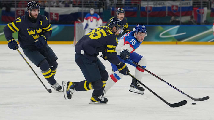 Feb 14, 2026; Milan, Italy; rik Karlsson of Sweden and Victor Hedman of Sweden in action with Dalibor Dvorsky of Slova during a Group B men's ice hockey game during the Milano Cortina 2026 Olympic Winter Games at Milano Santagiulia Ice Hockey Arena. Mandatory Credit: James Lang-Imagn Images