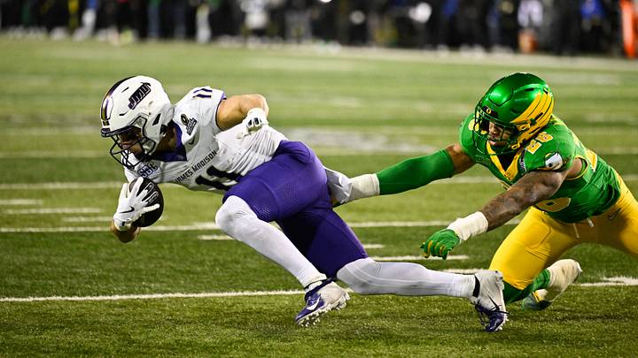 Dec 20, 2025; Eugene, OR, USA; James Madison Dukes wide receiver Nick Degennaro (11) makes a catch and is tripped up by Oregon Ducks linebacker Devon Jackson (26) during the fourth quarter at Autzen Stadium. Mandatory Credit: Troy Wayrynen-Imagn Images