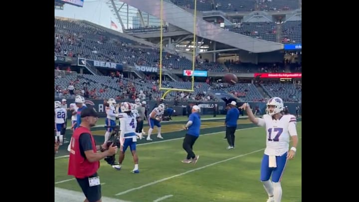 Josh Allen throws a football with a young Bills fan before a preseason game. 