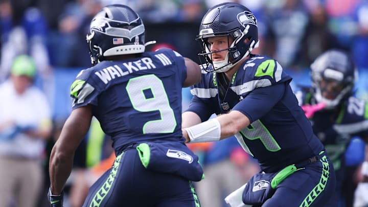Nov 9, 2025; Seattle, Washington, USA; Seattle Seahawks quarterback Sam Darnold (14) hands the ball off to Seattle Seahawks running back Kenneth Walker III (9) during the first quarter at Lumen Field. 