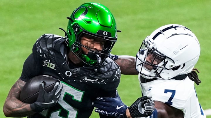 Oregon Ducks wide receiver Tez Johnson (15) stiff arms Penn State Nittany Lions cornerback Zion Tracy (7) 