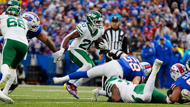 New York Jets running back Breece Hall (20) avoids several Bills players for a gain of several yards during first half action at the Bills home game against the New York Jets at Highmark Stadium in Orchard Park on Dec. 29, 2024.