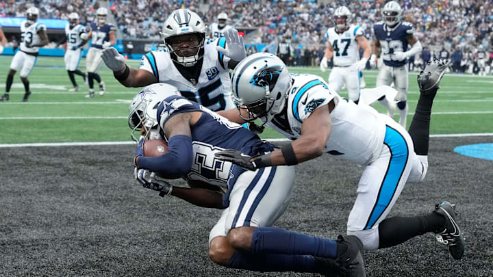 Dec 15, 2024; Charlotte, North Carolina, USA; Dallas Cowboys wide receiver Jalen Brooks (83) catches a touchdown pass as Carolina Panthers safety Xavier Woods (25) and cornerback Michael Jackson (2) defend in the third quarter at Bank of America Stadium.