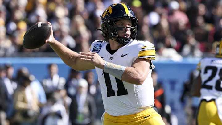 Dec 31, 2025; Tampa, FL, USA; Iowa Hawkeyes quarterback Mark Gronowski (11) throws a pass against the Vanderbilt Commodores in the first quarter during the ReliaQuest Bowl at Raymond James Stadium. Mandatory Credit: Nathan Ray Seebeck-Imagn Images