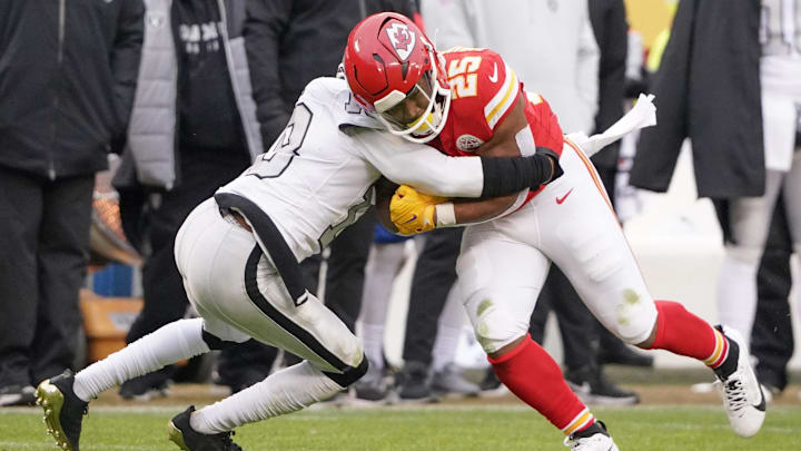 Dec 25, 2023; Kansas City, Missouri, USA; Kansas City Chiefs running back Clyde Edwards-Helaire (25) runs the ball as Las Vegas Raiders cornerback Jack Jones (18) makes the tackle during the game at GEHA Field at Arrowhead Stadium. Mandatory Credit: Denny Medley-Imagn Images