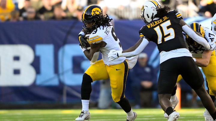 Dec 30, 2024; Nashville, TN, USA;  Iowa Hawkeye running back Jaziun Patterson (9) gets tackled from behind by Missouri Tigers defensive end Johnny Walker Jr. (15) during the first half at Nissan Stadium. Mandatory Credit: Steve Roberts-Imagn Images