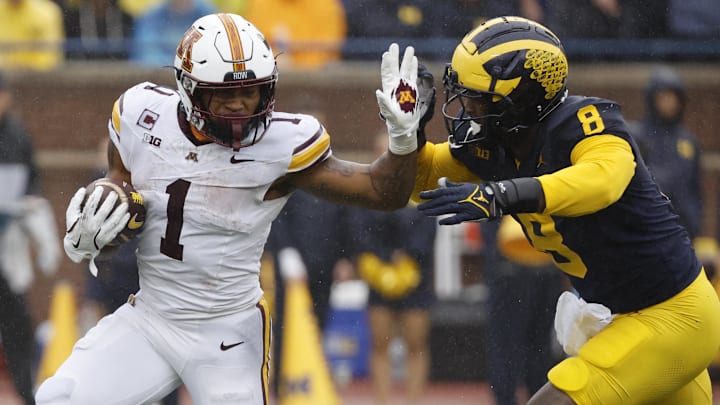 Minnesota running back Darius Taylor (1) rushes chased by Michigan defensive end Derrick Moore (8) in the first half at Michigan Stadium in Ann Arbor, Mich., on Sept. 28, 2024.