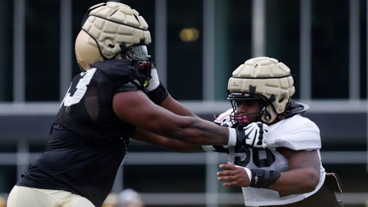 Purdue offensive lineman Marcus Mbow and defensive end Jayden Scruggs block each other