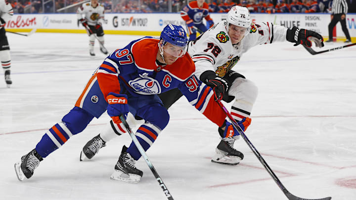 Nov 1, 2025; Edmonton, Alberta, CAN; Edmonton Oilers forward Connor McDavid (97) carries the puck around Chicago Blackhawks defensemen Alex Vlasic (72) during the third period at Rogers Place. Mandatory Credit: Perry Nelson-Imagn Images