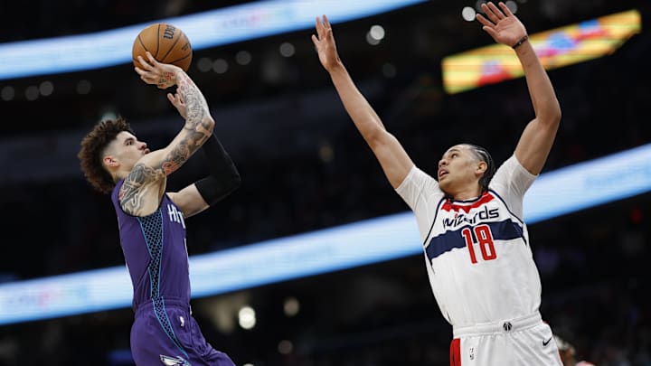 Dec 19, 2024; Washington, District of Columbia, USA; Charlotte Hornets guard LaMelo Ball (1) shoots the ball as Washington Wizards forward Kyshawn George (18) defends /d1qw/ at Capital One Arena. Mandatory Credit: Geoff Burke-Imagn Images