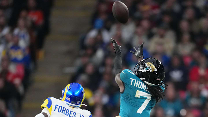 Oct 19, 2025; London, United Kingdom; Jacksonville Jaguars wide receiver Brian Thomas Jr. (7) reaches for the ball against Los Angeles Rams cornerback Emmanuel Forbes Jr. (1) during the second half of an NFL International Series game at Wembley Stadium. Mandatory Credit: Kirby Lee-Imagn Images Oct 19, 2025; London, United Kingdom; Jacksonville Jaguars wide receiver Brian Thomas Jr. (7) reaches for the ball against Los Angeles Rams cornerback Emmanuel Forbes Jr. (1) during the second half of an NFL International Series game at Wembley Stadium. Mandatory Credit: Kirby Lee-Imagn Images