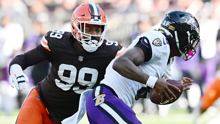 Oct 27, 2024; Cleveland, Ohio, USA; Cleveland Browns defensive end Za'Darius Smith (99) sacks Baltimore Ravens quarterback Lamar Jackson (8) during the second half at Huntington Bank Field. Mandatory Credit: Ken Blaze-Imagn Images