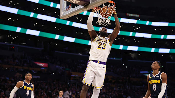 Nov 23, 2024; Los Angeles, California, USA: Los Angeles Lakers forward LeBron James (23) dunks the ball as Denver Nuggets guard Russell Westbrook (4) and forward Peyton Watson (8) watch during the third quarter at Crypto.com Arena. Mandatory Credit: Kiyoshi Mio-Imagn Images