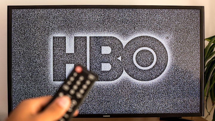 In this photo illustration a close-up of a hand holding a TV...