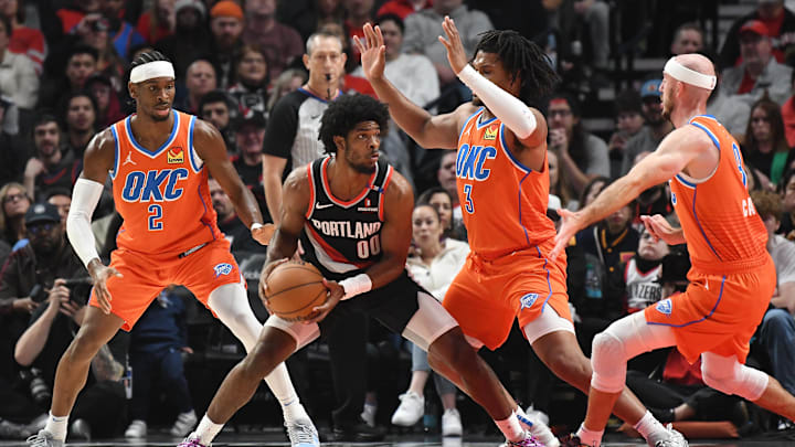 Nov 1, 2024; Portland, Oregon, USA; Portland Trail Blazers guard Scoot Henderson (00) looks to pass the ball against Oklahoma City Thunder forward Dillon Jones (3), guard Shai Gilgeous-Alexander (2) and guard Alex Caruso (9) during the second quarter at Moda Center. Mandatory Credit: Brian Murphy-Imagn Images Nov 1, 2024; Portland, Oregon, USA; Portland Trail Blazers guard Scoot Henderson (00) looks to pass the ball against Oklahoma City Thunder forward Dillon Jones (3), guard Shai Gilgeous-Alexander (2) and guard Alex Caruso (9) during the second quarter at Moda Center. Mandatory Credit: Brian Murphy-Imagn Images