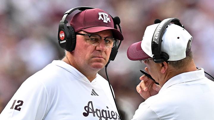 Texas A&M Aggies head coach Mike Elko speaks with a member of his coaching staff during a time-out in the fourth quarter against the Kentucky Wildcats at Kyle Field. Texas A&M Aggies head coach Mike Elko speaks with a member of his coaching staff during a time-out in the fourth quarter against the Kentucky Wildcats at Kyle Field.