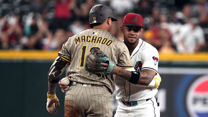 Aug 4, 2025; Phoenix, Arizona, USA; San Diego Padres third baseman Manny Machado (13) and Arizona Diamondbacks second baseman Ketel Marte (4) greet each other in the third inning at Chase Field. Mandatory Credit: Rick Scuteri-Imagn Images