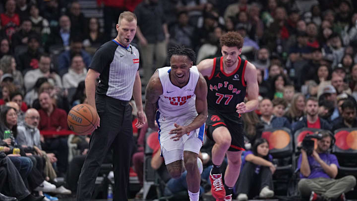 Nov 15, 2024; Toronto, Ontario, CAN; Detroit Pistons forward Ronald Holland II (00) and Toronto Raptors forward Jamison Battle (77) chase down the ball during the second quarter at Scotiabank Arena. Mandatory Credit: Nick Turchiaro-Imagn Images