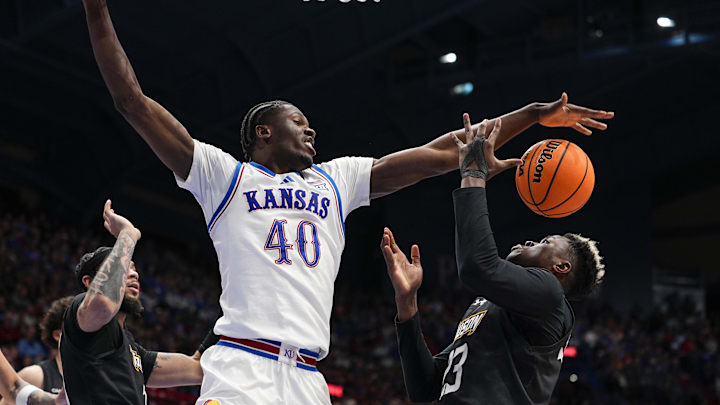 Dec 16, 2025; Lawrence, Kansas, USA; Kansas Jayhawks forward Flory Bidunga (40) and Towson Tigers forward Caleb Embeya (23) fight for a rebound during the second half at Allen Fieldhouse. Mandatory Credit: Jay Biggerstaff-Imagn Images