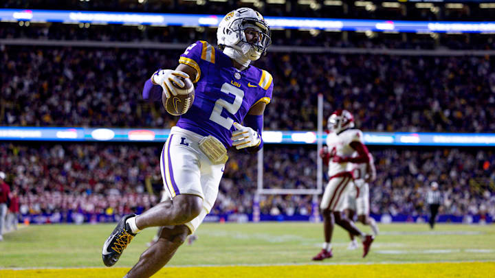 Nov 30, 2024; Baton Rouge, Louisiana, USA;  LSU Tigers wide receiver Kyren Lacy (2) runs after a catch and scores a touchdown against Oklahoma Sooners defensive back Billy Bowman Jr. (2) during the first quarter at Tiger Stadium. Mandatory Credit: Stephen Lew-Imagn Images
