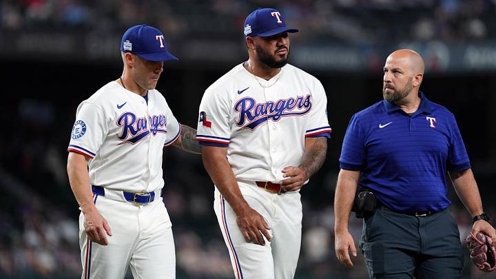 Texas Rangers pitcher Luis Curvelo walks off the field with manager Skip Schumaker and a trainer.