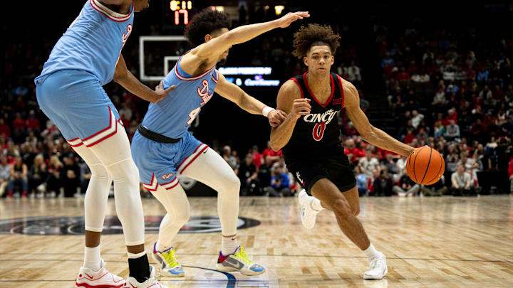 Cincinnati Bearcats guard Dan Skillings Jr. (0) drives on Dayton Flyers guard Koby Brea (4) in the first half of the NCAA men's basketball game between the Dayton Flyers and Cincinnati Bearcats at Heritage Bank Center in Cincinnati on Saturday, Dec. 16, 2023. Cincinnati Bearcats guard Dan Skillings Jr. (0) drives on Dayton Flyers guard Koby Brea (4) in the first half of the NCAA men's basketball game between the Dayton Flyers and Cincinnati Bearcats at Heritage Bank Center in Cincinnati on Saturday, Dec. 16, 2023.