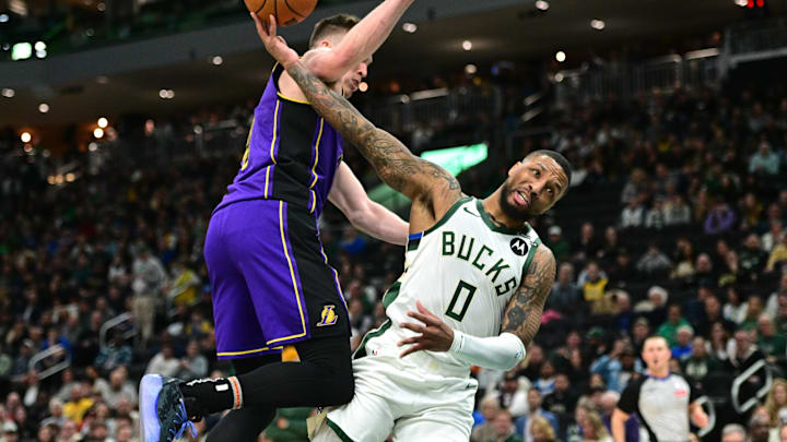 Mar 13, 2025; Milwaukee, Wisconsin, USA: Milwaukee Bucks guard Damian Lillard (0) is fouled by Los Angeles Lakers forward Dalton Knecht (4) in the second quarter at Fiserv Forum. Mandatory Credit: Benny Sieu-Imagn Images