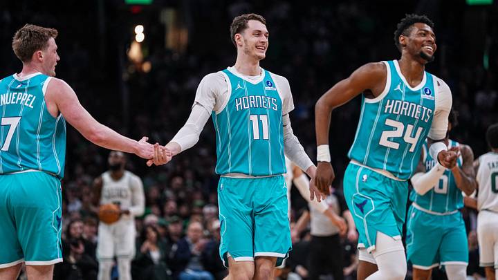Charlotte Hornets center Ryan Kalkbrenner (11), forward Brandon Miller (24) and guard Kon Knueppel (7) react