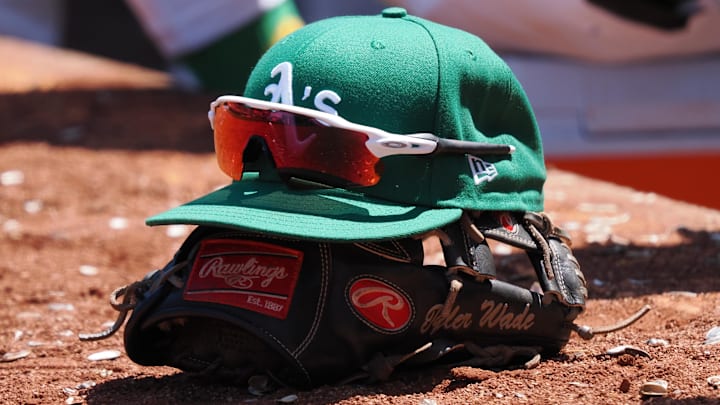Jun 29, 2023; Oakland, California, USA; An Oakland Athletics hat on top of a glove during the eighth inning at Oakland-Alameda County Coliseum. Mandatory Credit: Kelley L Cox-Imagn Images