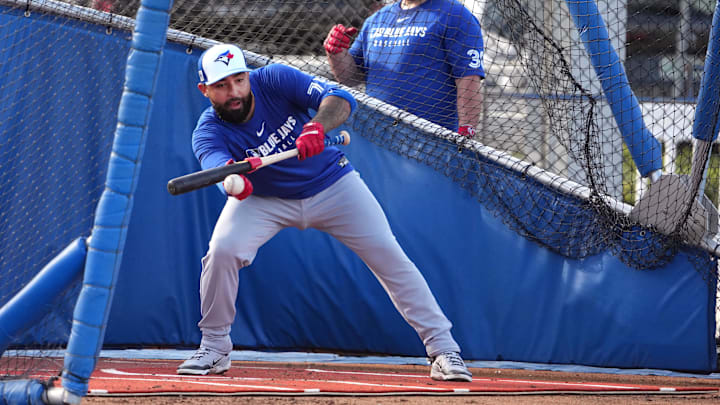 Feb 16, 2025; Dunedin, FL, USA; Toronto Blue Jays Ali Sanchez (75) bunts the ball as catcher Alejandro Kirk (30) looks on during spring training practice at TD Ballpark. 