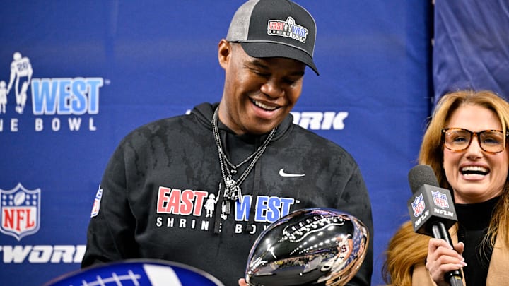 West head coach Lunda Wells holds the game trophy after the game at the Ford Center at the Star. 