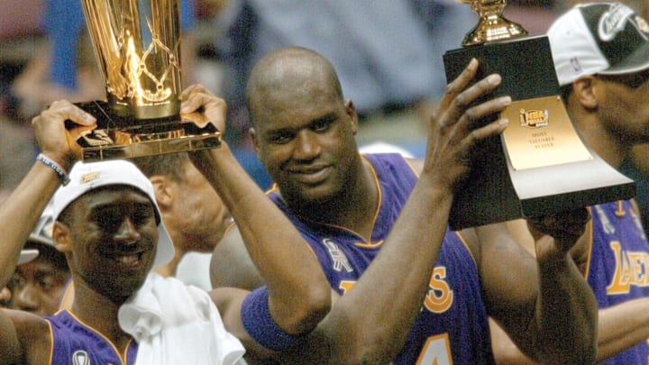June 12, 2002; East Rutherford, NJ, USA; (left to right) Los Angeles Lakers Kobe Bryant and Shaquille O'Neal hold trophies after winning the championship in Game 4 of the NBA Finals at The Meadowlands.  Mandatory Credit: Robert Deutsch-USA TODAY Sports