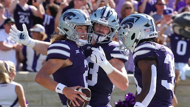 Sep 28, 2024; Manhattan, Kansas, USA; Kansas State Wildcats quarterback Avery Johnson (2) celebrates with running back Dylan Edwards (3) and running back DJ Giddens (31) after scoring a touchdown against the Oklahoma State Cowboys in the first quarter at Bill Snyder Family Football Stadium. Mandatory Credit: Scott Sewell-Imagn Images