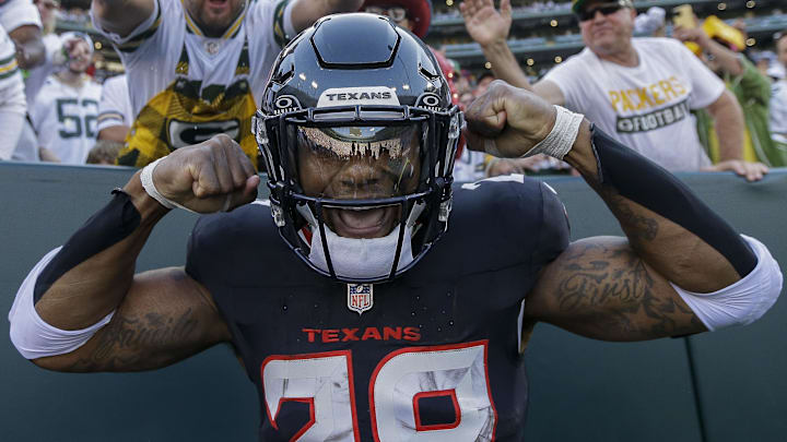 Oct 20, 2024; Green Bay, Wisconsin, USA; Houston Texans running back Joe Mixon (28) flexes after doing a “Lambeau Leap” after his first rushing touchdown against the Green Bay Packers  at Lambeau Field. Mandatory Credit: Tork Mason/Green Bay Press-Gazette via the USA TODAY NETWORK-Wisconsin-Imagn Images