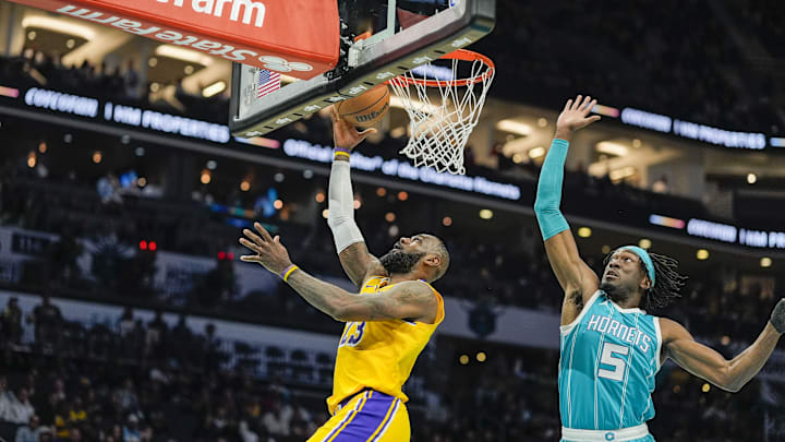 Jan 27, 2025; Charlotte, North Carolina, USA;  Los Angeles Lakers forward LeBron James (23) makes a layup past Charlotte Hornets center Mark Williams (5) during the first quarter at the Spectrum Center. Mandatory Credit: Jim Dedmon-Imagn Images