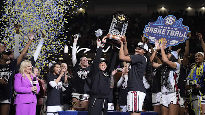 March 9, 2025; Greenville, SC, USA; South Carolina Gamecocks head coach Dawn Staley hoists the SEC Championship Trophy after her teams win over Texas during the SEC Women’s Tournament at Bon Secours Wellness Arena. Mandatory Credit: Jim Dedmon-Imagn Images