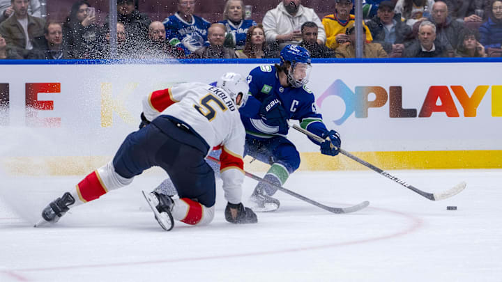 Dec 12, 2024; Vancouver, British Columbia, CAN; Florida Panthers defenseman Aaron Ekblad (5) defends against Vancouver Canucks defenseman Quinn Hughes (43) during the second period at Rogers Arena. Mandatory Credit: Bob Frid-Imagn Images