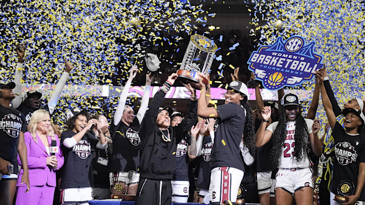 Mar 9, 2025; Greenville, SC, USA;  South Carolina Gamecocks head coach Dawn Staley and forward Sania Feagin (20) hoist the SEC Championship Trophy after her teams win over Texas during the SEC Womenís Tournament at Bon Secours Wellness Arena. Mandatory Credit: Jim Dedmon-Imagn Images