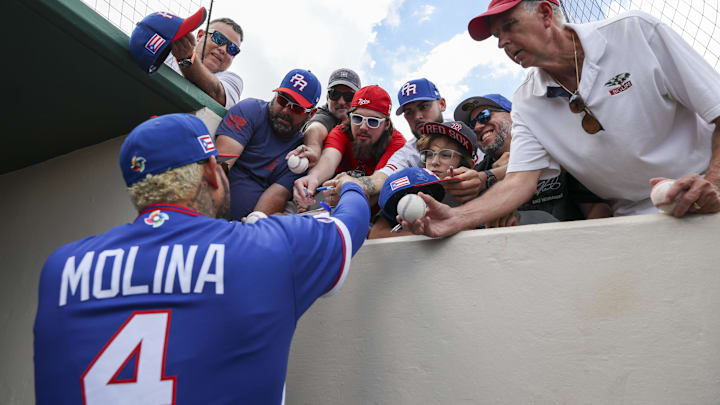 Mar 4, 2026; Fort Myers, Florida, USA; Puerto Rico manager Yadier Molina (4) signs autographs for fans before a  spring training exhibition game against the Minnesota Twins at Lee Health Sports Complex/Hammond Stadium. Mandatory Credit: Nathan Ray Seebeck-Imagn Images