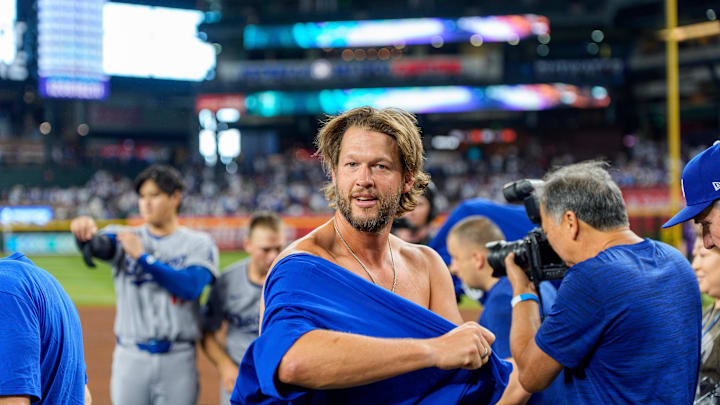 Los Angeles Dodgers pitcher Clayton Kershaw (22) reacts as he puts on his National League West championship shirt after beating the Arizona Diamondbacks at Chase Field on Sept. 25. Los Angeles Dodgers pitcher Clayton Kershaw (22) reacts as he puts on his National League West championship shirt after beating the Arizona Diamondbacks at Chase Field on Sept. 25.