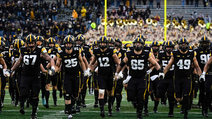 The Iowa Hawkeyes swarm to the Floyd of Rosedale Trophy after defeating the Minnesota Golden Gophers Oct. 25, 2025 at Kinnick Stadium in Iowa City, Iowa.