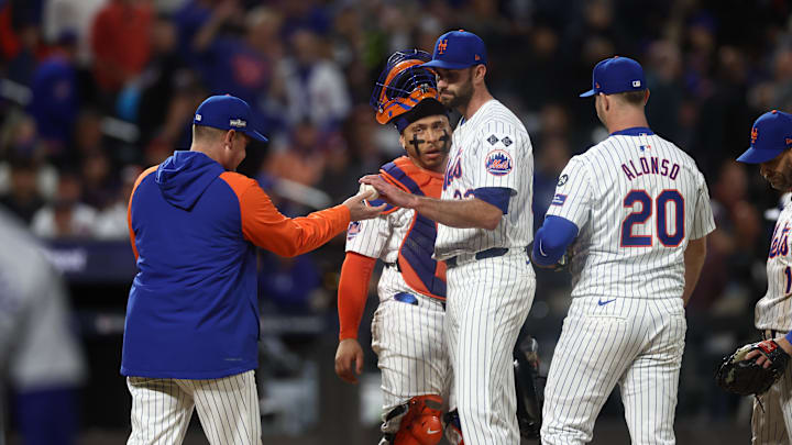 Oct 18, 2024; New York City, New York, USA; New York Mets pitcher David Peterson (23) hands the ball to New York Mets manager Carlos Mendoza (64) during the fourth inning against the Los Angeles Dodgers during game five of the NLCS for the 2024 MLB playoffs at Citi Field. Mandatory Credit: Vincent Carchietta-Imagn Images