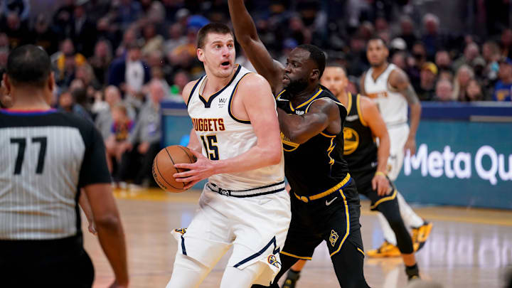 Denver Nuggets center Nikola Jokic (15) controls the ball against Golden State Warriors forward Draymond Green (23) in the second quarter during game one of the first round for the 2022 NBA playoffs at the Chase Center. Mandatory Credit: Cary Edmondson-Imagn Images