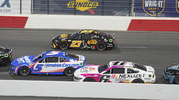 May 19, 2024; North Wilkesboro, North Carolina, USA;  NASCAR Cup Series driver Bubba Wallace (23) is forced high in turn three during the All Star race at North Wilkesboro Speedway. Mandatory Credit: Jim Dedmon-Imagn Images